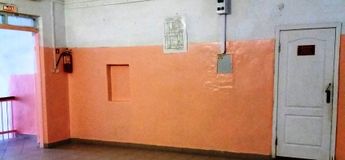 Указатель выхода и план эвакуации в школьном коридоре